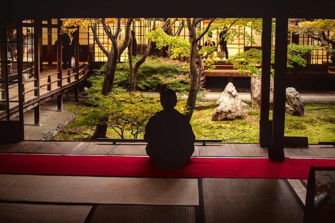 Sakin bir Japon bahçesinde meditasyon yapan bir kişi