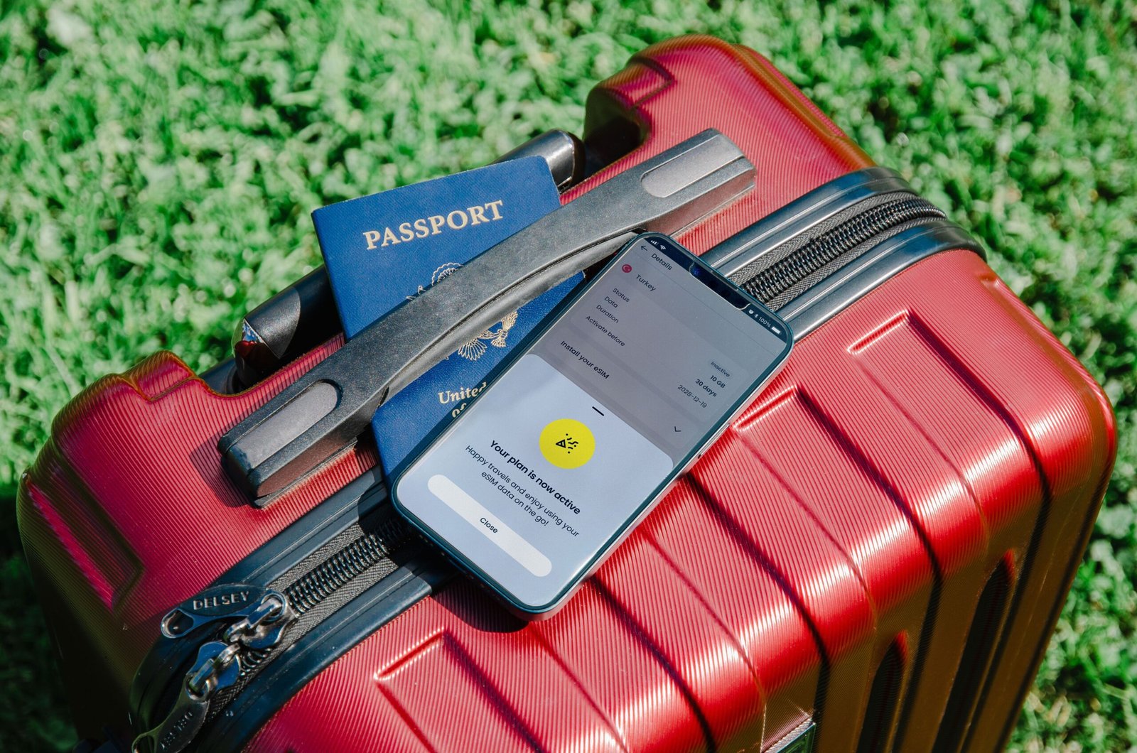 Kırmızı valiz üzerinde pasaport ve akıllı telefon