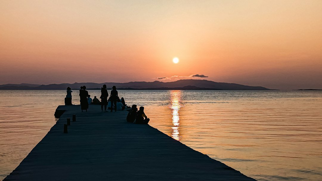 Taketomi Adası'nda iskelede gün batımını izleyen insanlar, Yaeyama