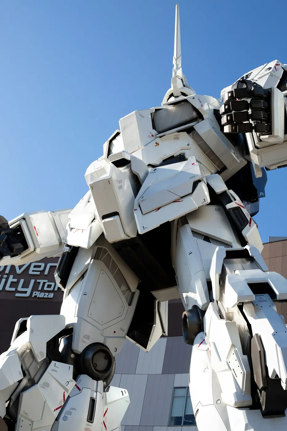 Yeşil ağaçlarla çevrili Gundam heykeli