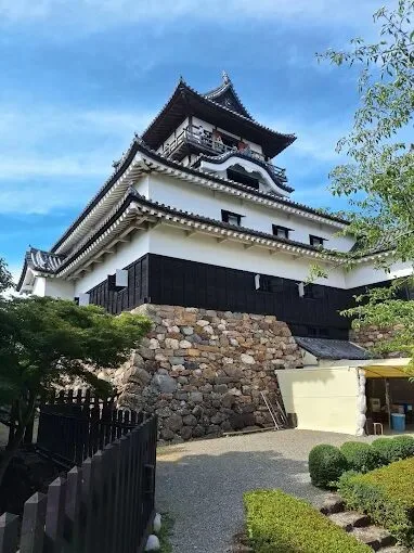 Taş temel üzerinde yükselen siyah-beyaz Inuyama Kalesi ana kulesi alttan görünümü