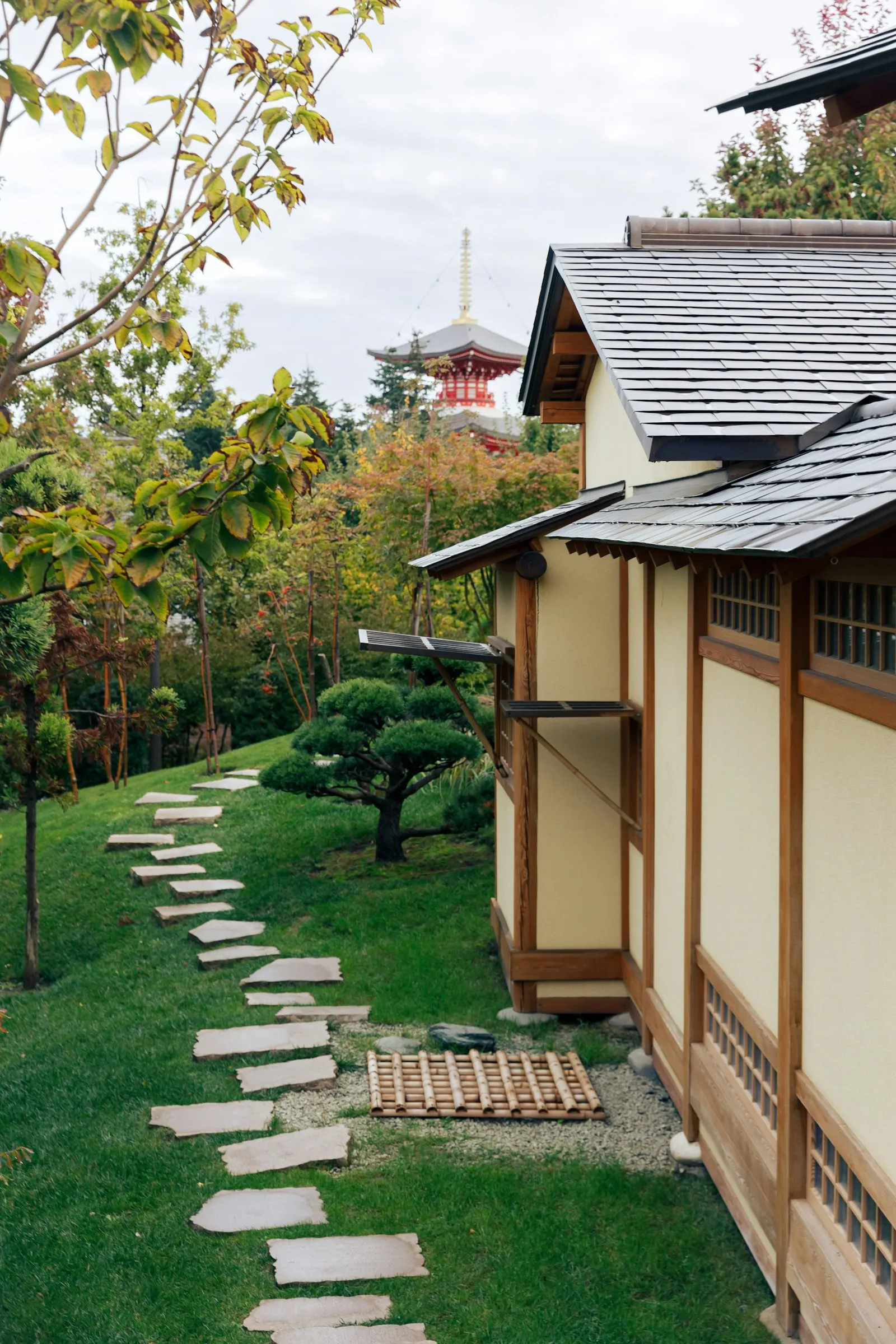 Japon bahçesinde bir yapının yanından geçen taş patika
