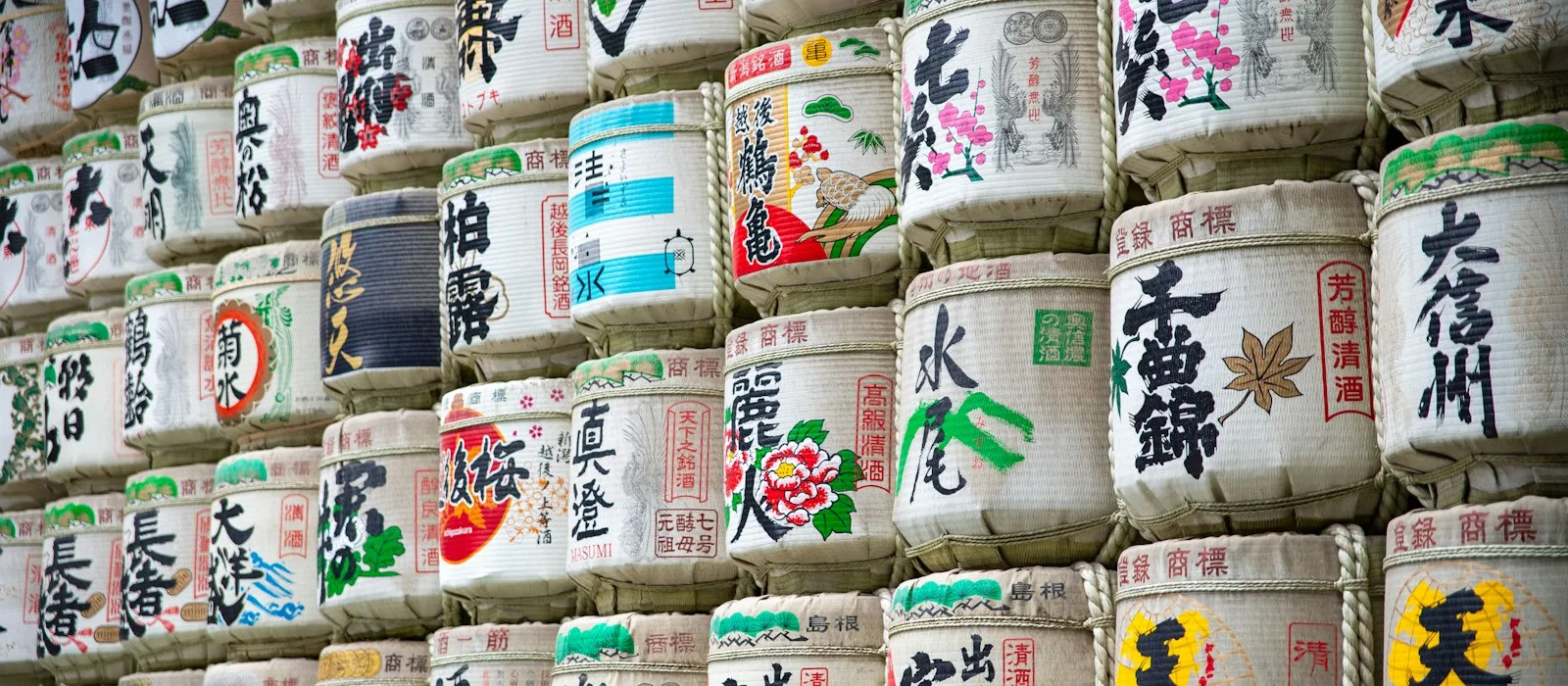 Japonca yazılı sake fıçılarından oluşan duvar