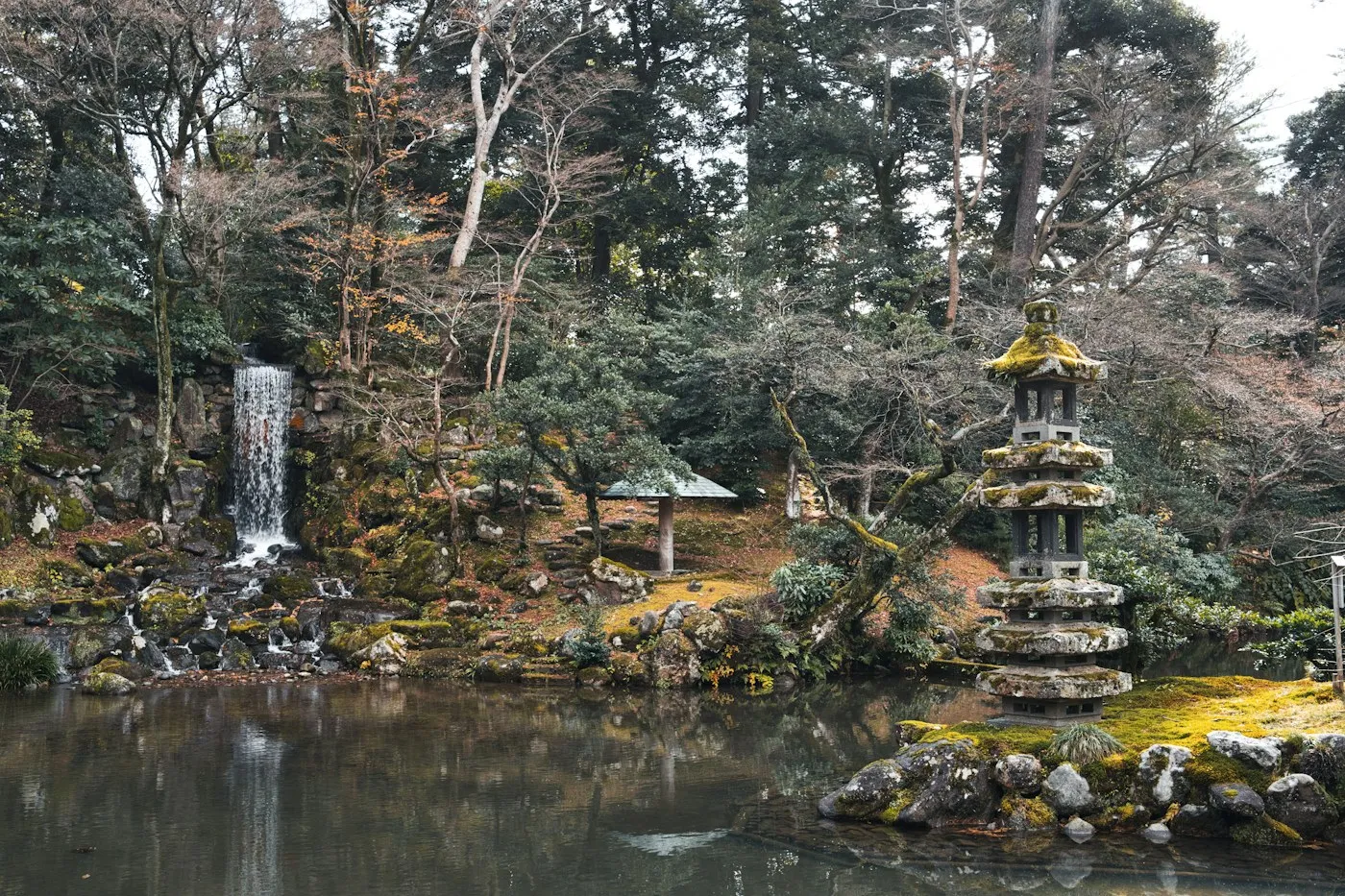 Şelale, taş pagoda ve yosunlu kayalar