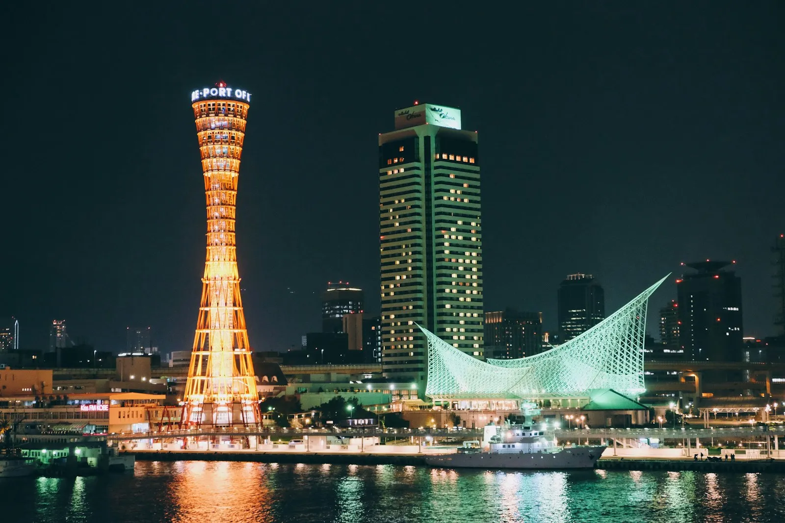 Gece ışıklarıyla Kobe Port Tower ve liman