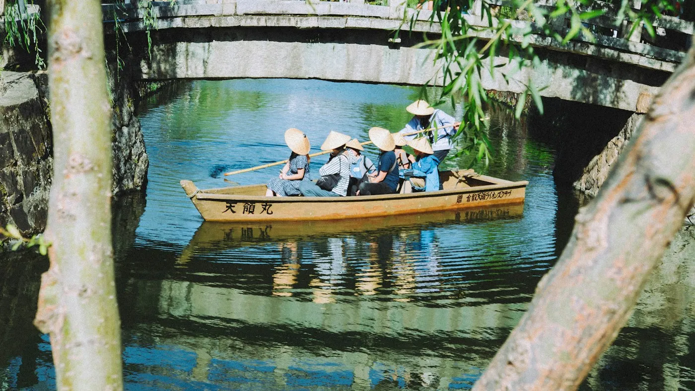 Kurashiki kanalında köprü altından geçen tekne