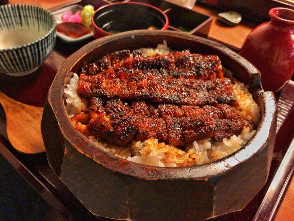 Ahşap kapta servis edilen, üzeri ızgara yılan balığı kaplı Nagoya hitsumabushi'si
