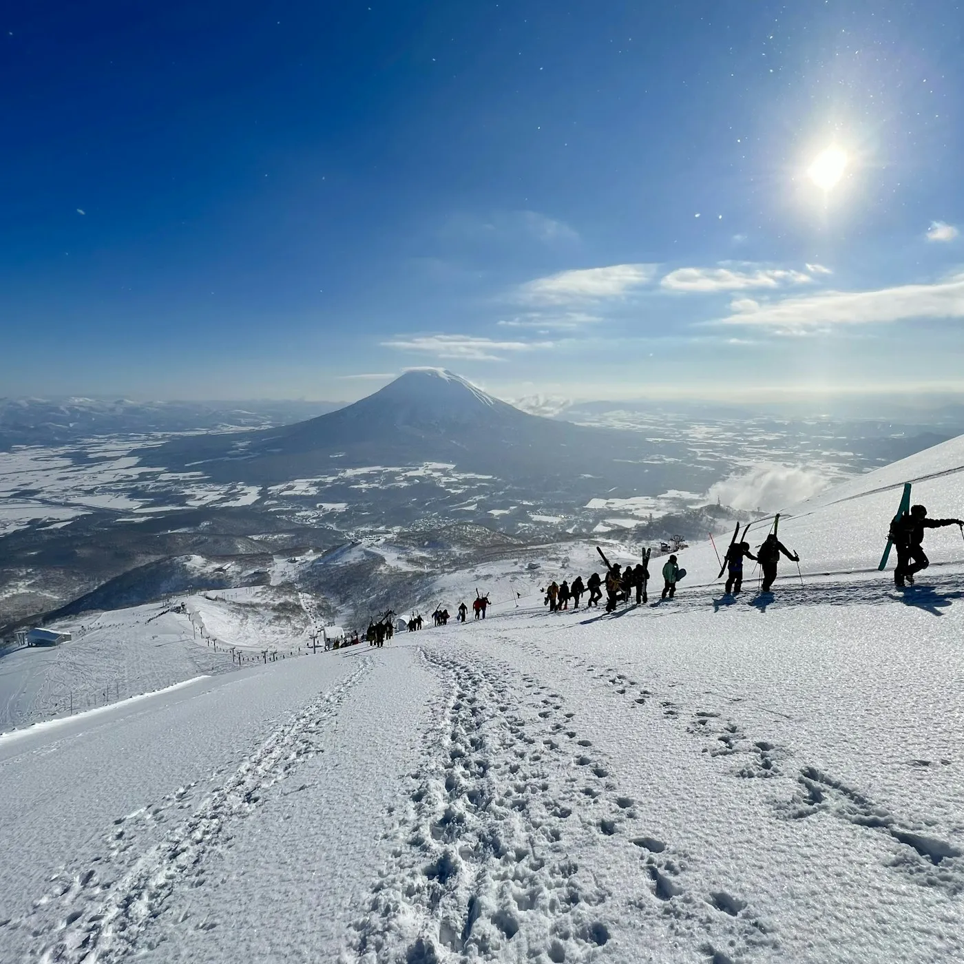 Kayakla yükselen kişiler ve arkada Yotei Dağı