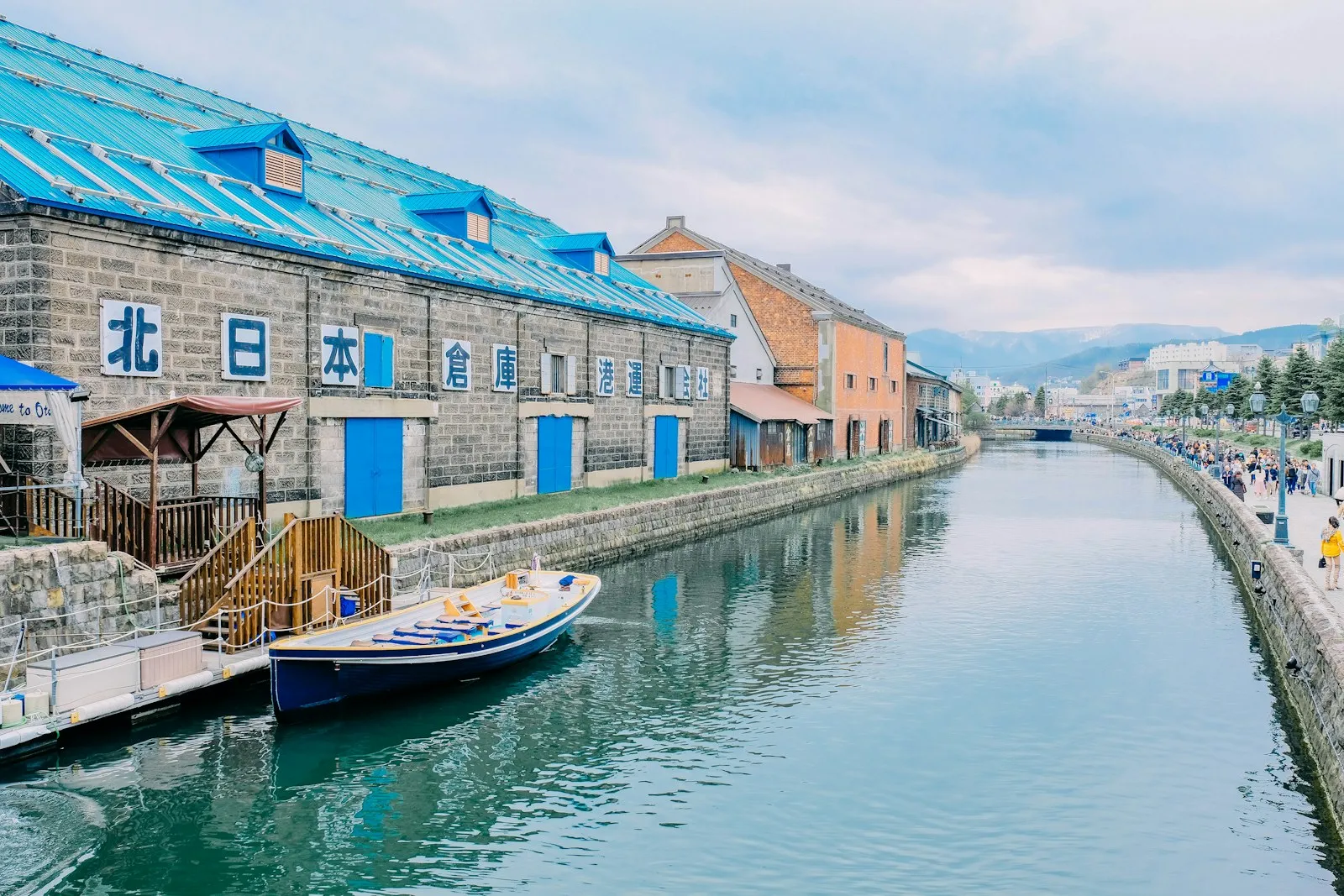 Otaru Kanalı kıyısında taş depolar, mavi kepenkler ve su yansıması