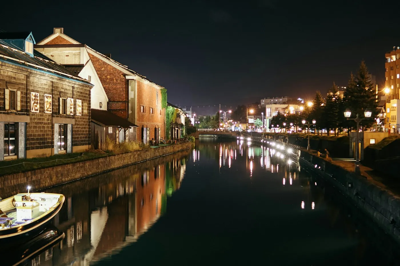 Gece lambalarla aydınlanmış kanal ve tekneler