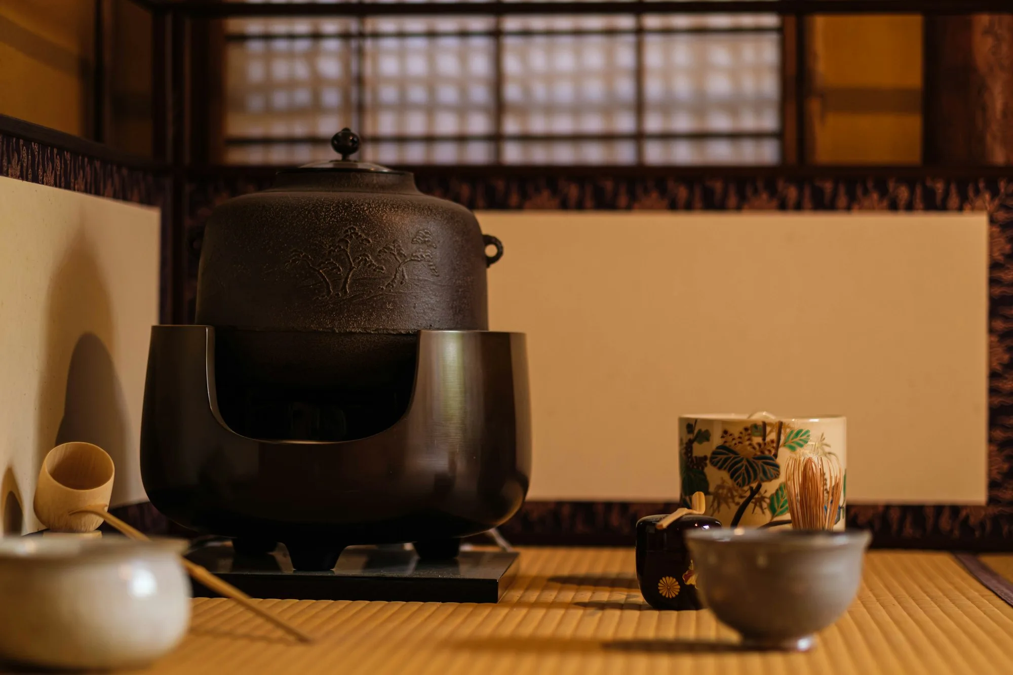 Tatami odada demir çay ibriği, bambu kepçe ve çay kâseleri